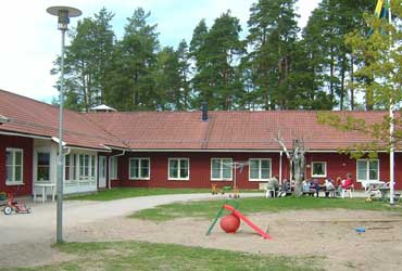 Årsunda förskola ligger i en röd enplansbyggnad. Framför huset finns lekredskap och en grön gräsyta